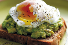 Nutritious and flavorful breakfast featuring creamy mashed avocado and a perfectly poached egg on top of hearty whole grain toast.